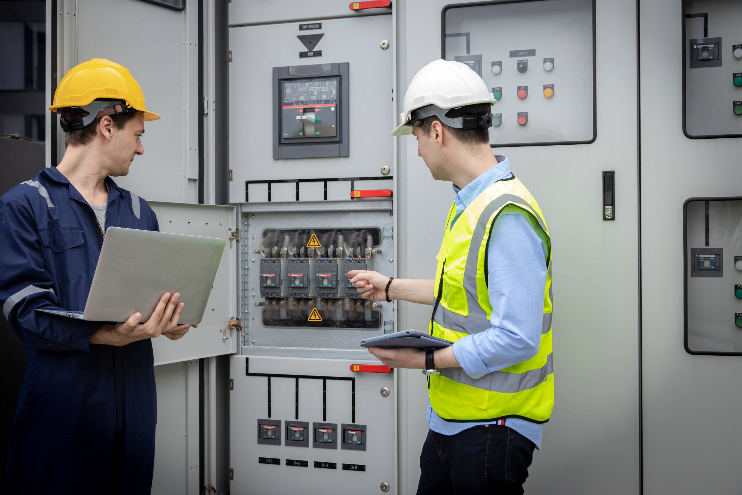 Electrical engineer working in control room. Electrical engineer man checking Power Distribution Cabinet in the control room